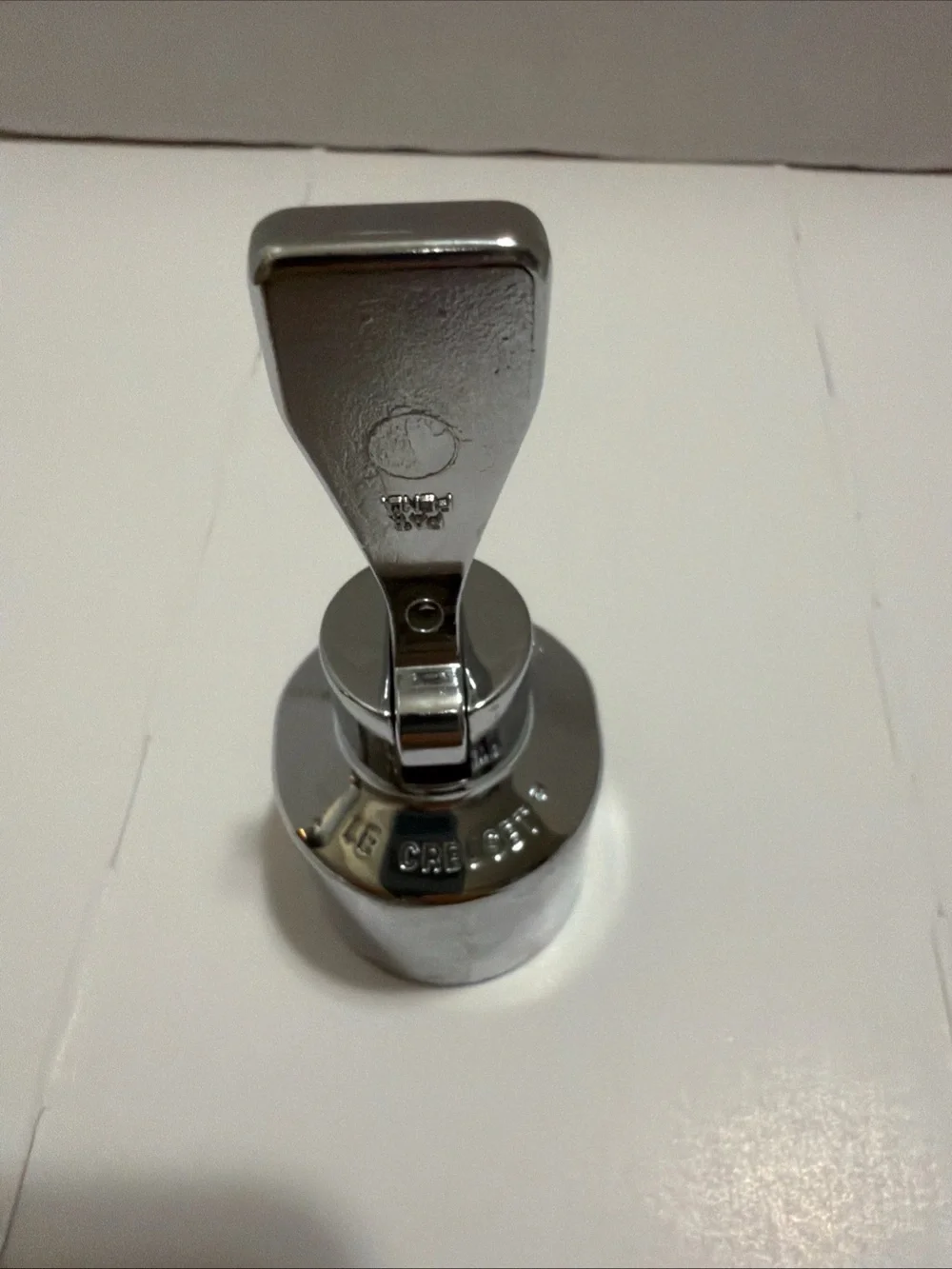 Le Creuset Champagne Crown Sealer, specifically a satin chrome.